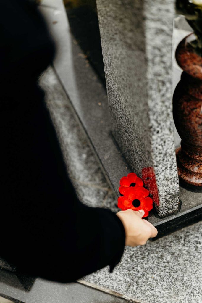 A red poppy placed on a headstone