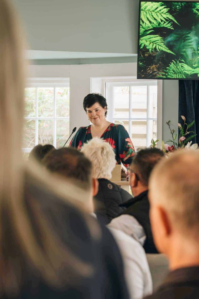 A celebrant speaking to family and friends at a service